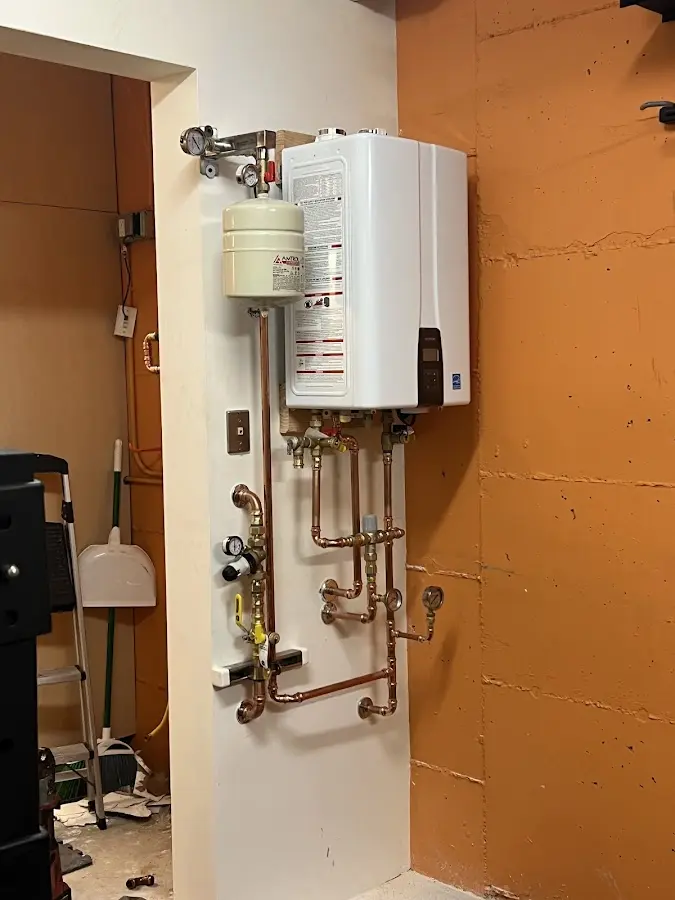 Plumbing technician inspecting water heater connections in Port Angeles East